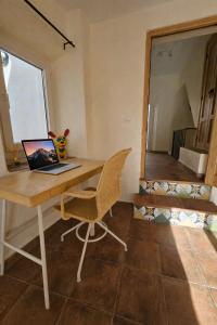 a desk with a laptop and a chair in a room at Olé Toledo in Cómpeta