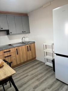a kitchen with a white refrigerator and wooden cabinets at Casa Rural SERAGAL in El Bonillo
