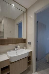 a bathroom with a white sink and a mirror at Skypark Celeste with stunning golf course view in Laguna Phuket +22 photos