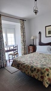 ein Schlafzimmer mit einem Bett, einem Stuhl und einem Fenster in der Unterkunft Hotel Los Caspios in Colunga