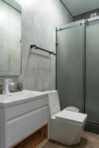 a bathroom with a white sink and a shower at Nord Karakol Hotel in Karakol +25 photos