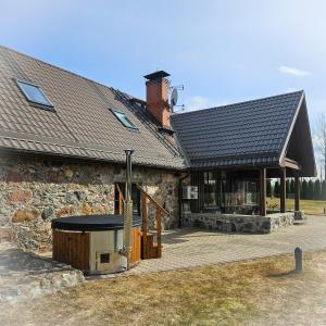 a stone building with a table in front of it at Jauki Lauki in Lejasciems
