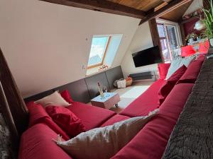 a living room with red pillows on a bed at Historische Ferienwohnung mit Sauna und Dachterrasse in Lich +7 photos