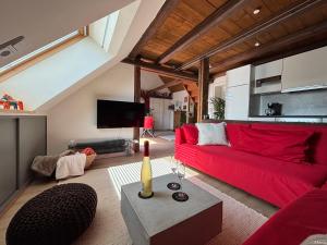 a living room with a red couch and a table at Historische Ferienwohnung mit Sauna und Dachterrasse in Lich