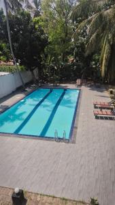 a large swimming pool with blue water at Pearl City Resort in Tissamaharama