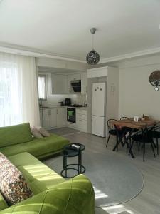 a living room with a green couch and a table at YoYo Apart in Dalaman