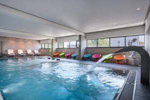 a pool in a hotel with a water fountain at Hôtel Restaurant Athena Spa in Strasbourg