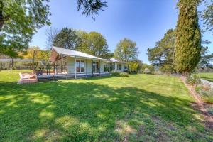 a house with a large yard in front of it at Three Pines on Grange in Porepunkah