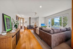 a living room with a couch and a large window at Three Pines on Grange in Porepunkah