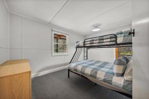 a bedroom with two bunk beds in a room at Three Pines on Grange in Porepunkah