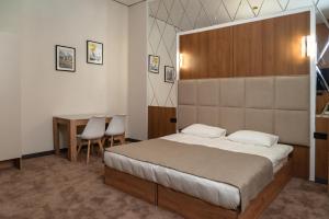 a bedroom with a bed and a table in it at Nord Karakol Hotel in Karakol