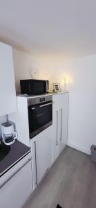 a kitchen with a stove and a microwave at Birkenhain in Geltorf
