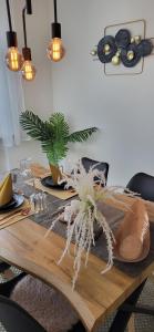 a dining room table with a potted plant on it at Birkenhain in Geltorf