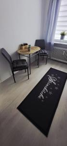 a black rug on the floor in a room with a table at Birkenhain in Geltorf +12 photos