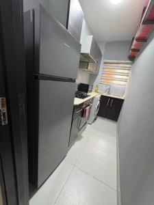 a small kitchen with a refrigerator and a stove at Pinecourt Luxury Apartment in Ikate