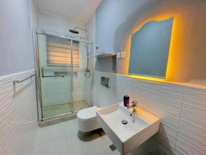 a bathroom with a sink and a shower and a toilet at Pinecourt Luxury Apartment in Ikate