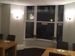 a meeting room with a window and tables and chairs at Richmond House Hotel in Southport