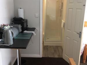 a room with a counter with a microwave and a door at Richmond House Hotel in Southport