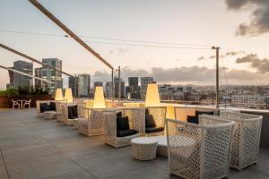 a row of tables and chairs on a roof at Hotel SB Plaza Europa in Hospitalet de Llobregat