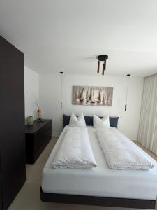 a large white bed with white sheets and pillows at Villa Čapula - Modern Apartment with Sea View and Parking, Marušići in Omiš