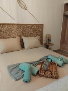 a bed with towels and a basket on it at Seaview Apartments in Anavyssos
