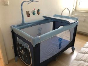 a baby crib with a tv in a room at Ferienwohnung in der Villa Seestern in Nienhagen