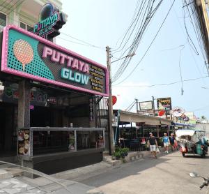 a sign for a pizza shop on a city street at Puttaya Glow in Pattaya