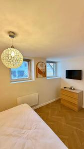 a bedroom with a bed and a flat screen tv at La petite maison orange in Koenigsmacker