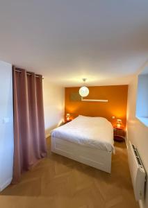 a bedroom with a white bed and orange walls at La petite maison orange in Koenigsmacker +18 photos