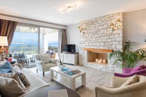 a living room with a brick fireplace and a couch at Three Stones Villas by Rodostamo Collection in Kassiopi