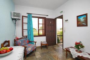 a living room with a table and a chair and a door at Kastri in Panormos Skopelos