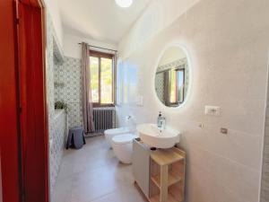 a white bathroom with a sink and a toilet at Villa Angelina - Lake View Dreams in Cannero Riviera
