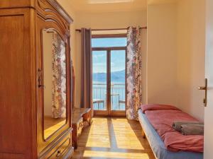 a bedroom with a bed and a large window at Villa Angelina - Lake View Dreams in Cannero Riviera