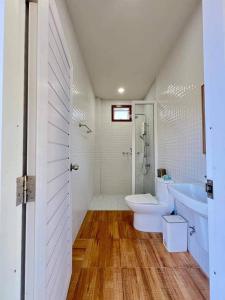 a bathroom with a toilet and a tub and a sink at Lamae Beachfront Villa in Ban Laem No +14 photos