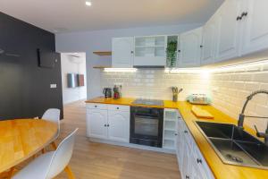 a kitchen with white cabinets and a wooden table at Lar de Sefa 15 in Redondela