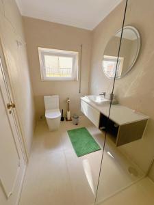 a bathroom with a toilet and a sink and a mirror at Bay Golf House in Cascais