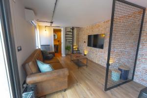 a living room with a couch and a brick wall at Lar de Sefa 15 in Redondela