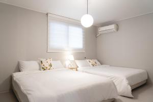 ein Schlafzimmer mit zwei Betten und einem Fenster in der Unterkunft 스테이솜 in Daejeon