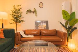 a living room with a brown couch and a glass table at Cozy 2 6 Guest Stay near Gangnam 6 min from Nakseongdae Station in Samgong