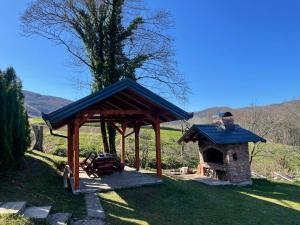 a gazebo with a brick oven in the grass at Vikendica Krupa in Banja Luka