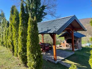 a gazebo with a grill next to a tree at Vikendica Krupa in Banja Luka