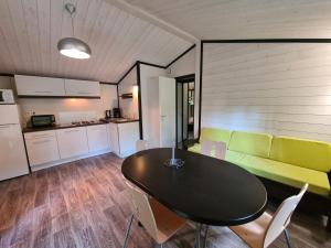 a living room with a table and a green couch at Les Buissonnets in Saint-Georges-de-Didonne