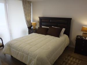 1 dormitorio con 1 cama grande y 2 lámparas en Departamento 193, en Coquimbo