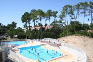 a swimming pool at a resort with people in it at Les Buissonnets in Saint-Georges-de-Didonne