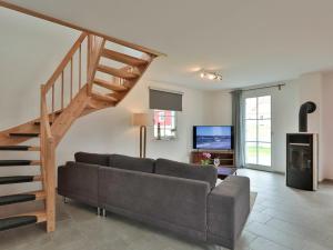 a living room with a couch and a wooden staircase at FH Seeschwalbe in Niendorf