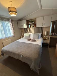 a bedroom with a large bed with two towels on it at Dulce Casa 34 2 bedroom with hot tub in Grantown on Spey