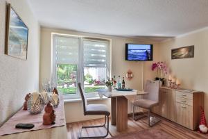 a living room with a table and a window at Bungalow Konrad in Kühlungsborn