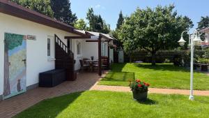 a house with a yard with a patio at Bungalow Konrad in Kühlungsborn