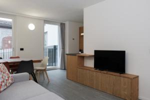 a living room with a flat screen tv on a cabinet at Casa Bepa in Bormio