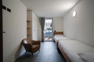 a row of beds in a room with a chair at Casa Bepa in Bormio